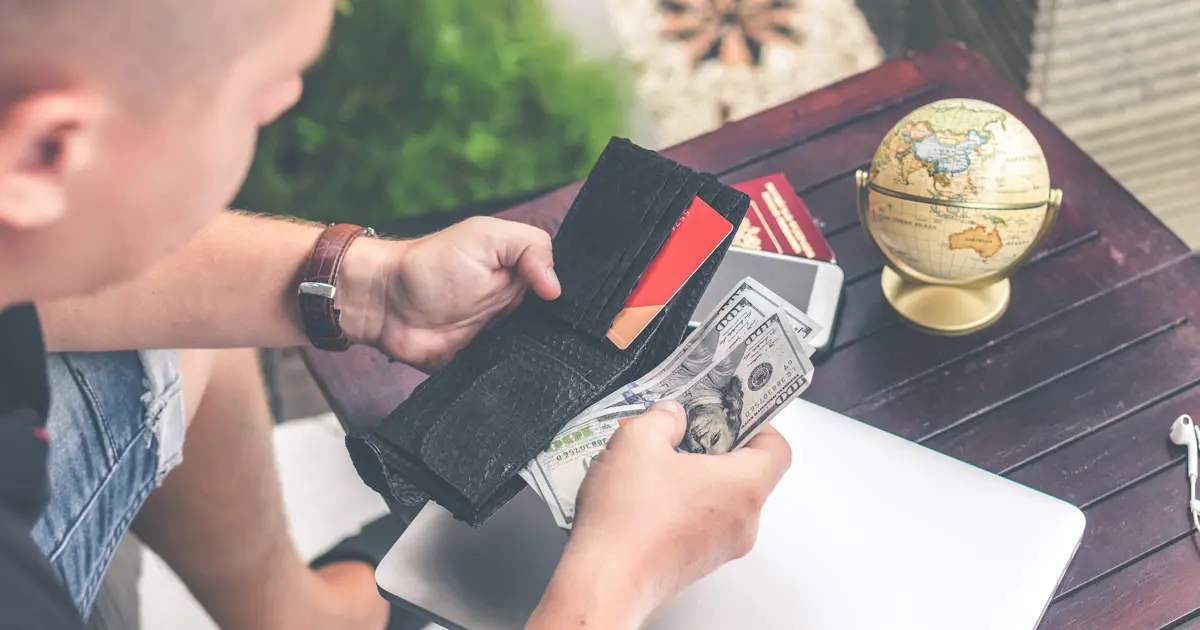 Man counting dollar bills from wallet