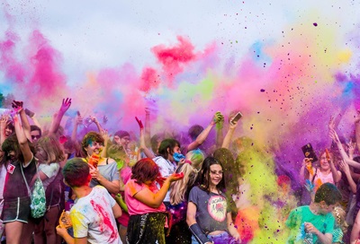 People enjoying the vibrant colors of holi powder during the Holi Festival in India.