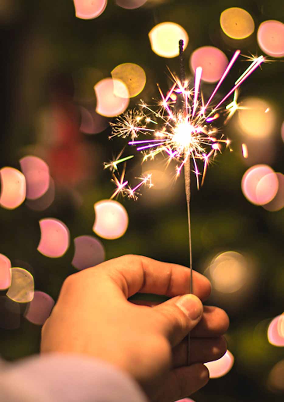 A person holding a sparkling stick. 