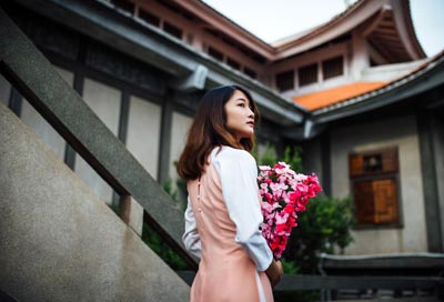 Asian woman holding pink flowers